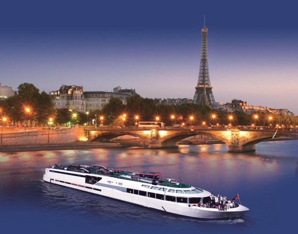 un bateau sur la rivière en face de la tour eiffel dans l'établissement VIP Paris Yacht Hôtel & Spa, à Paris