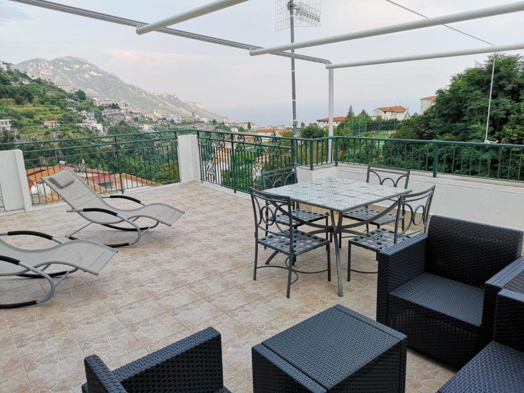 een patio met een tafel en stoelen op een balkon bij Nonna Rosa House in Scala