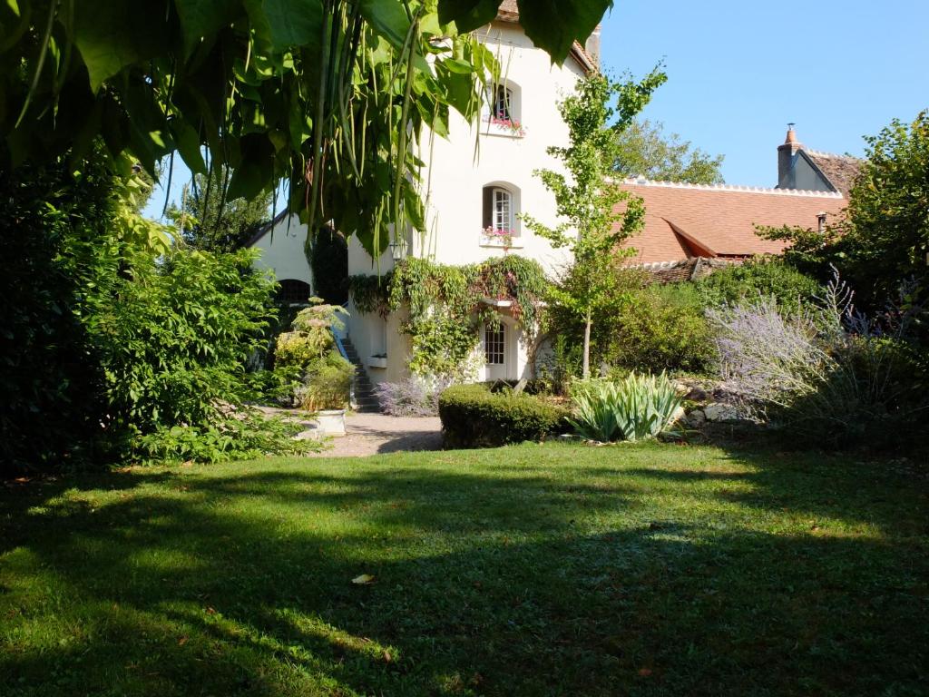 una casa blanca con un patio con árboles y arbustos en La Pouillyzotte, en Pouilly-sur-Loire
