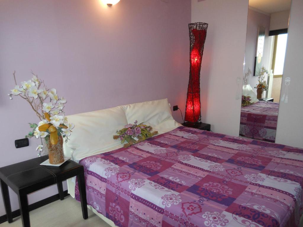 een slaapkamer met een bed en een vaas met bloemen op een tafel bij Motel Monterosa in Vogogna