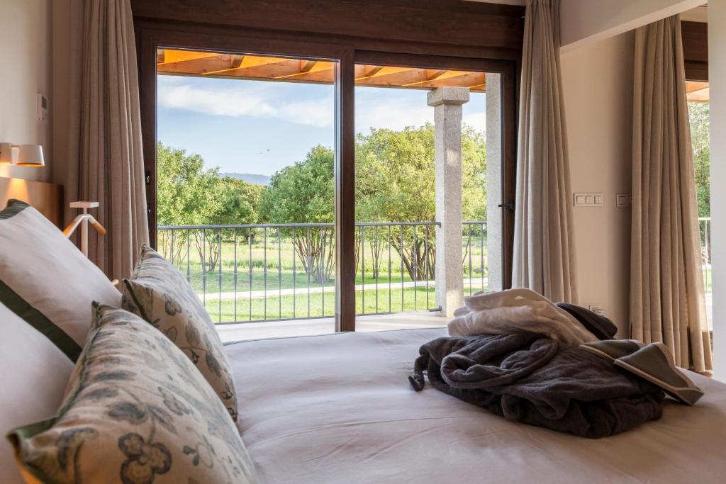 Bett in einem Zimmer mit einem großen Fenster in der Unterkunft A Maquia in Poio