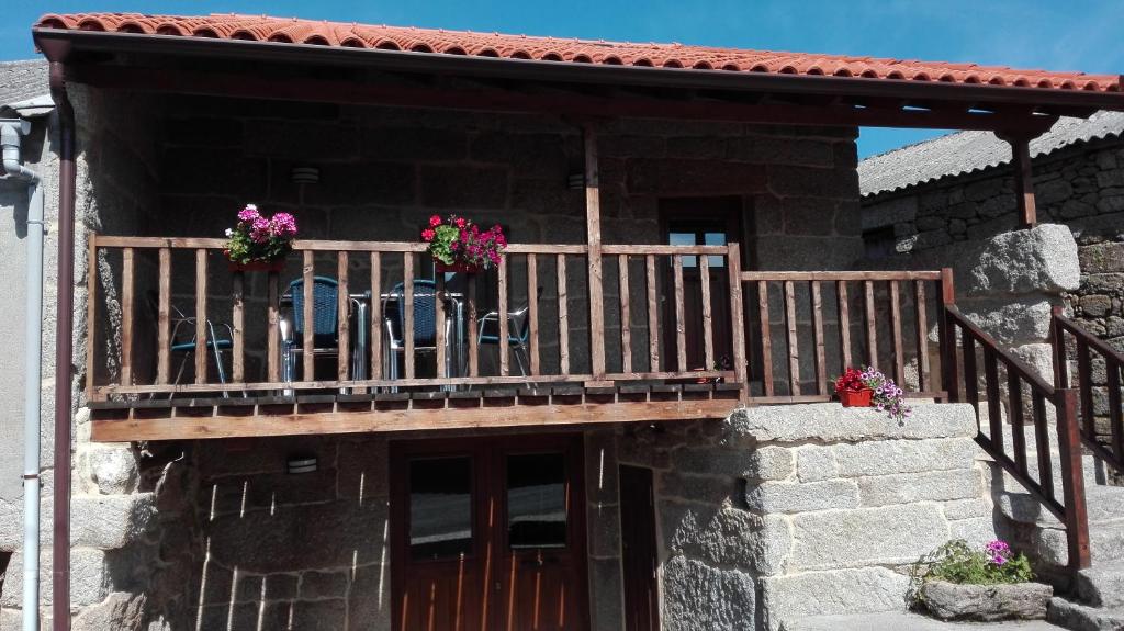 Un balcón de una casa con flores. en Casa do Xurés, en Maus de Salas