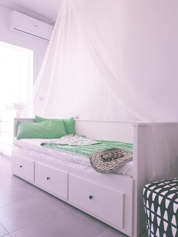 ein weißes Bett mit Baldachin in einem Schlafzimmer in der Unterkunft Cosy studio apartment in Torrevieja in Torrevieja