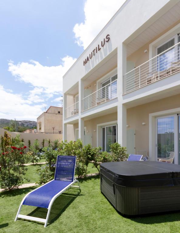 a villa with a lawn in front of a building at Hotel Nautilus in Cagliari