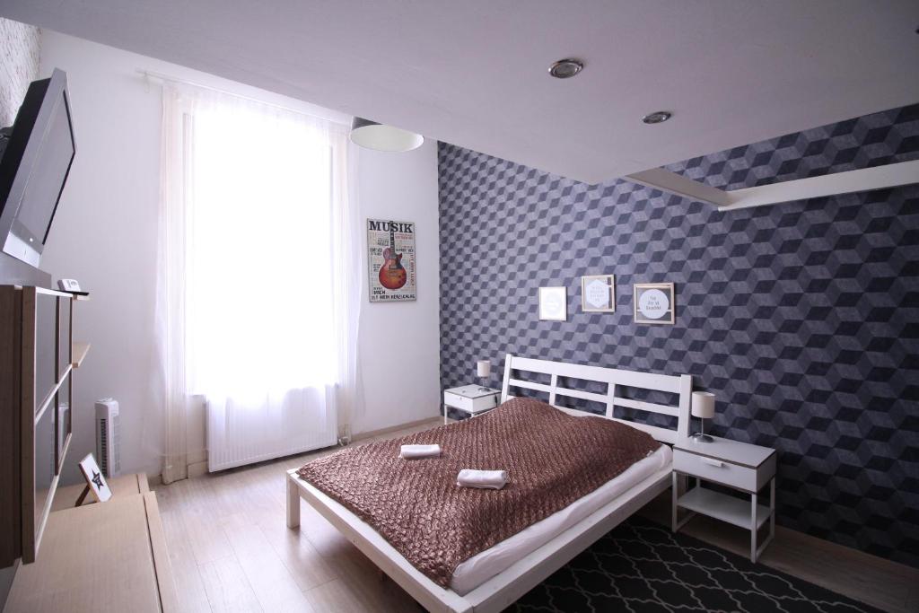 ブダペストにあるSusan Apartment near Blaha Lujza Squareのチェッカーで囲まれた壁のベッドルーム1室