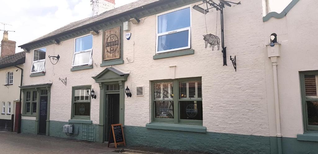 a white building with a sign in front of it at Pepper Street Rooms in Whitchurch