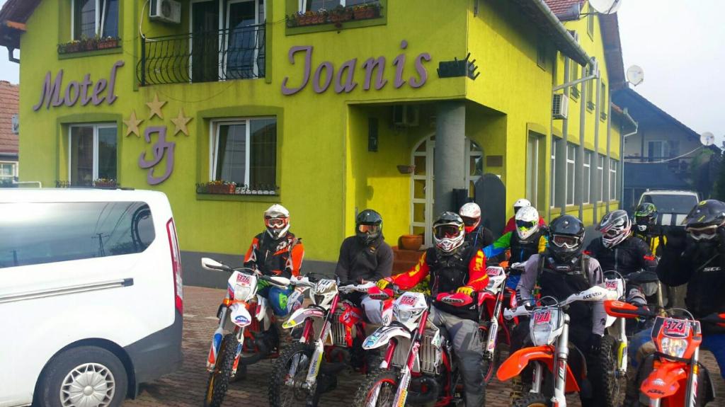a group of people on motorcycles parked in front of a building at Motel Ioanis in Mîndruloc