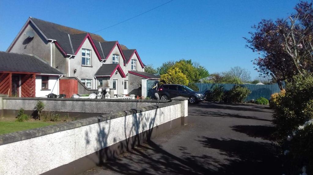 un grupo de casas con un coche aparcado en la entrada en Gortin Glen Guest House, en Garvagh