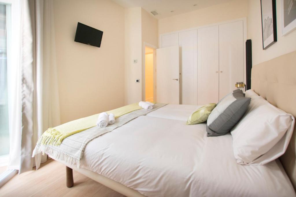 een slaapkamer met een groot wit bed en handdoeken bij Minty Stay - Paz in Madrid