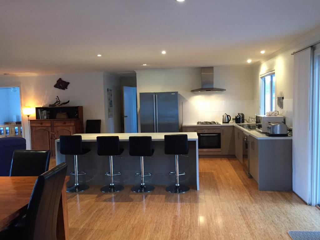 a kitchen with a counter and bar stools at My Island Home in Kingscote