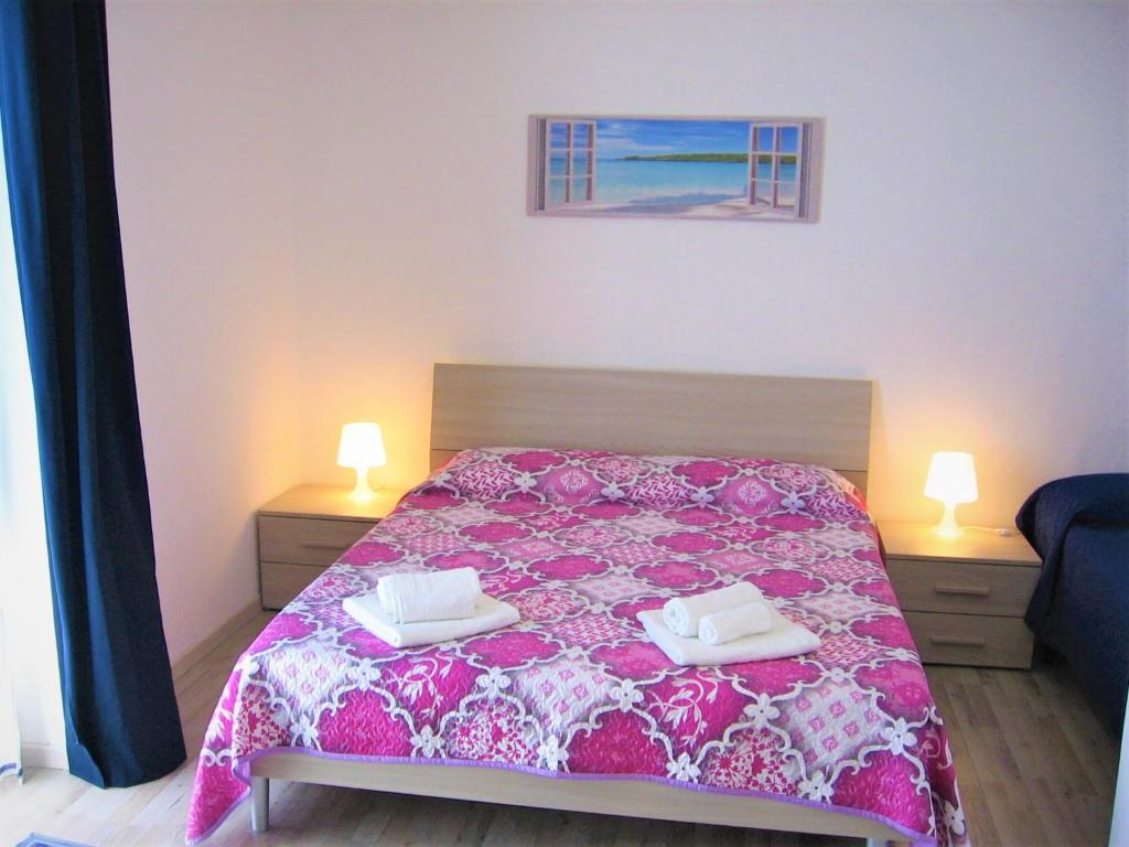 MazzarinoにあるCasa Principe Umbertoのベッドルーム1室(ピンクのベッドカバー付)