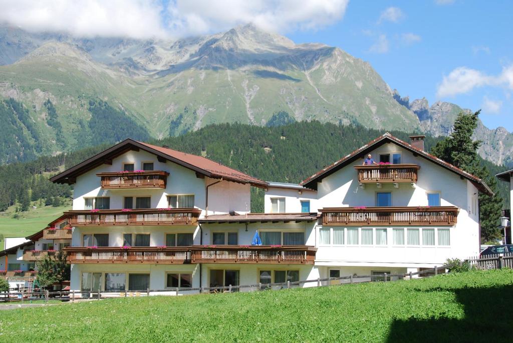 a large white building with mountains in the background at Alpenpension Regina in Nauders