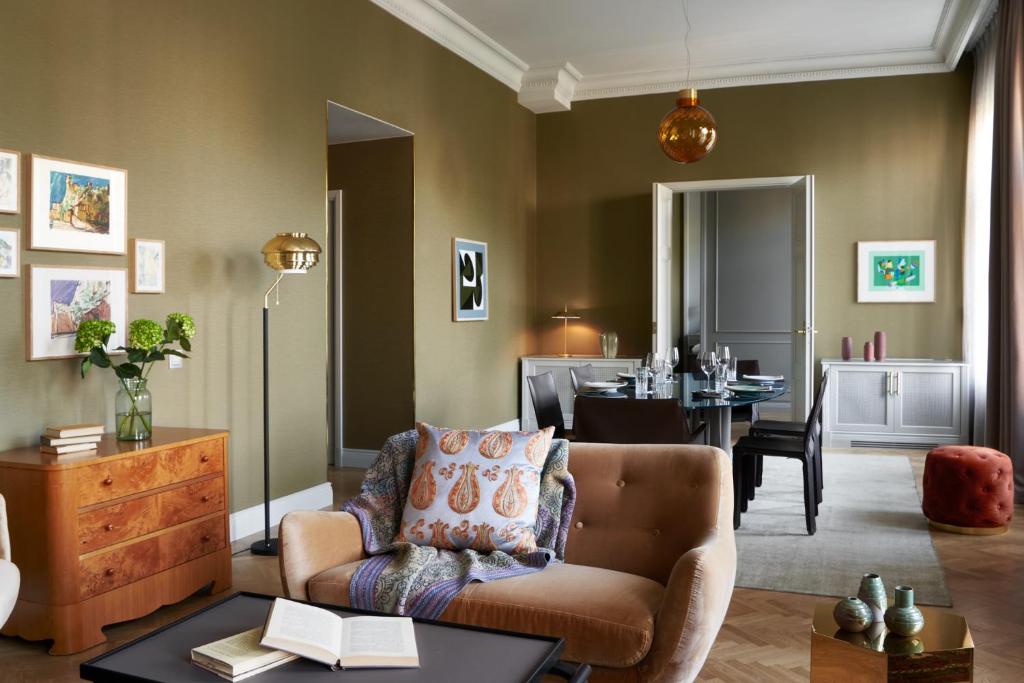 a living room with a couch and a dining room at Hotel St. George Helsinki in Helsinki