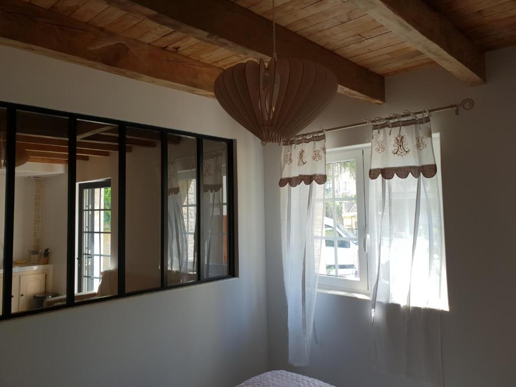 ein Schlafzimmer mit einem Spiegel und einem Fenster in der Unterkunft Studio Fontaine d’amour in Sarlat-la-Canéda