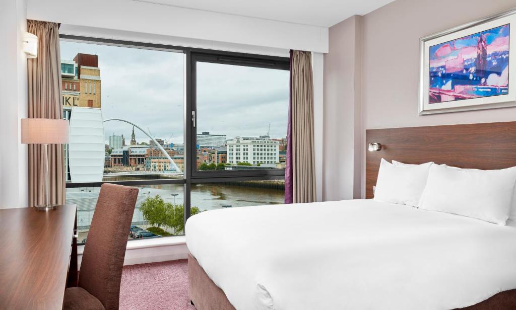 a hotel room with a large window overlooking the ocean at Jurys Inn Newcastle Quayside in Newcastle upon Tyne