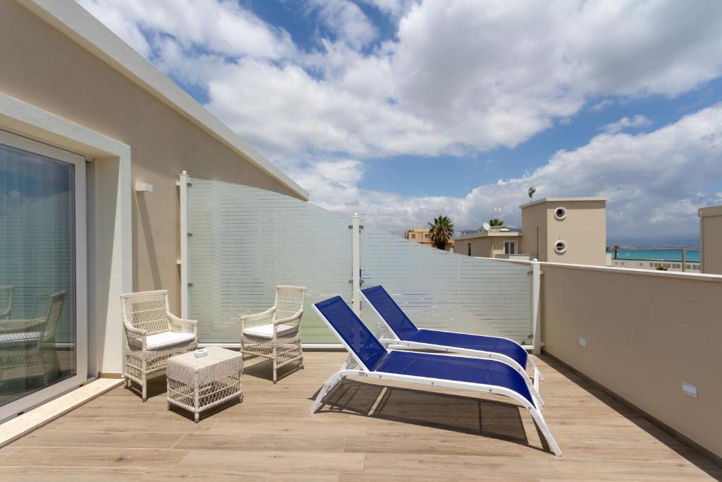 a pair of blue chairs on a balcony at Hotel Nautilus in Cagliari