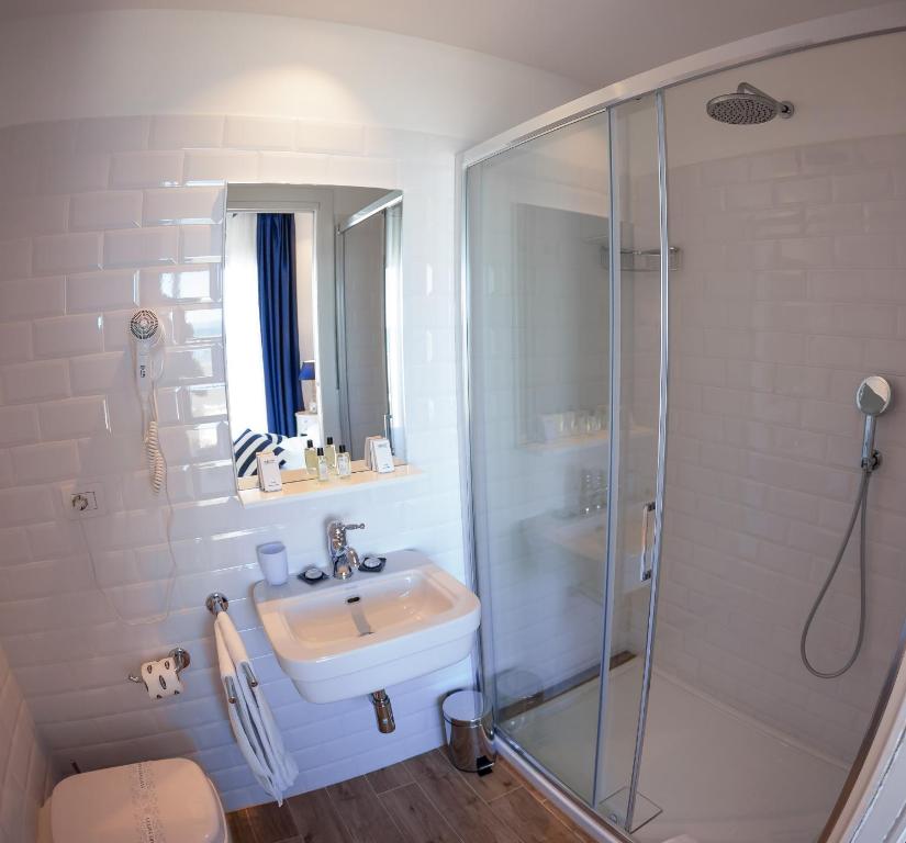 a bathroom with a glass shower and a sink at Hotel Nautilus in Cagliari