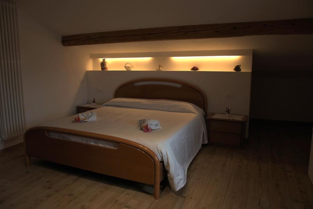 ein Schlafzimmer mit einem großen Bett mit einer weißen Decke in der Unterkunft Bed and Breakfast Ai Sassi in Sovramonte