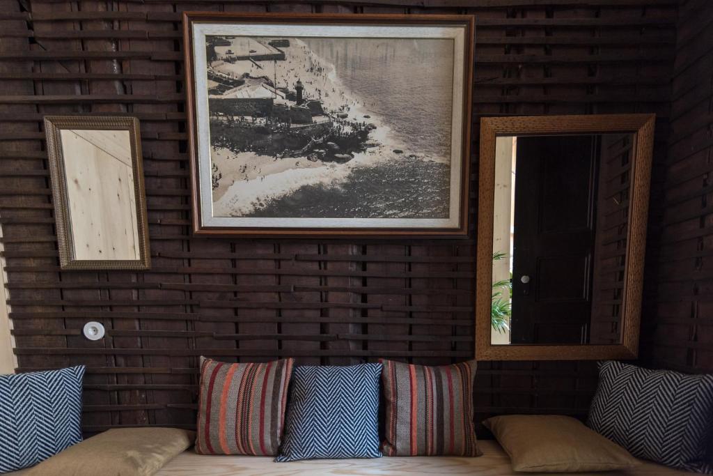 a living room with a couch and a picture on a brick wall at Chez Odete in Figueira da Foz