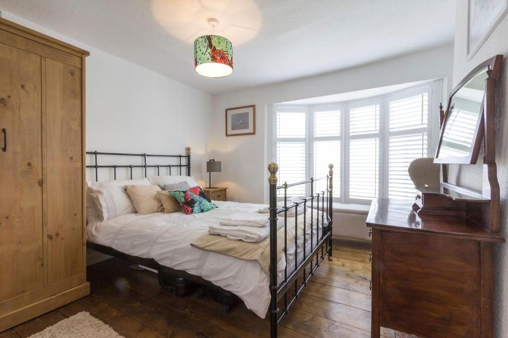 1 dormitorio con 1 cama y TV en Marine Cottage, en Whitstable