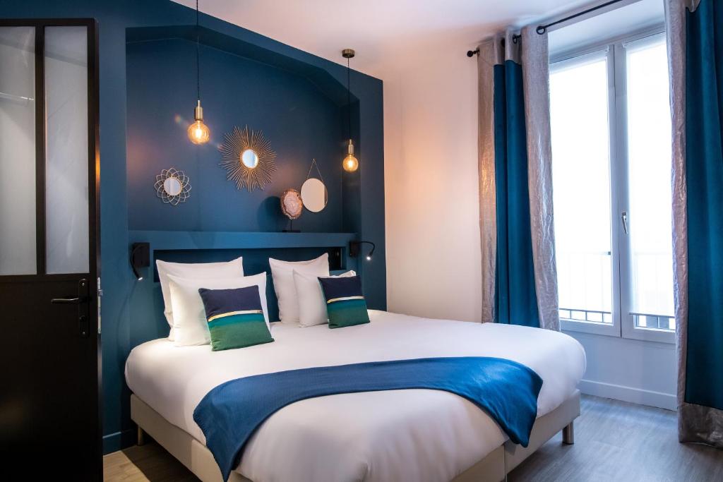 um quarto com uma cama grande e paredes azuis em Hôtel Royal Opéra em Paris