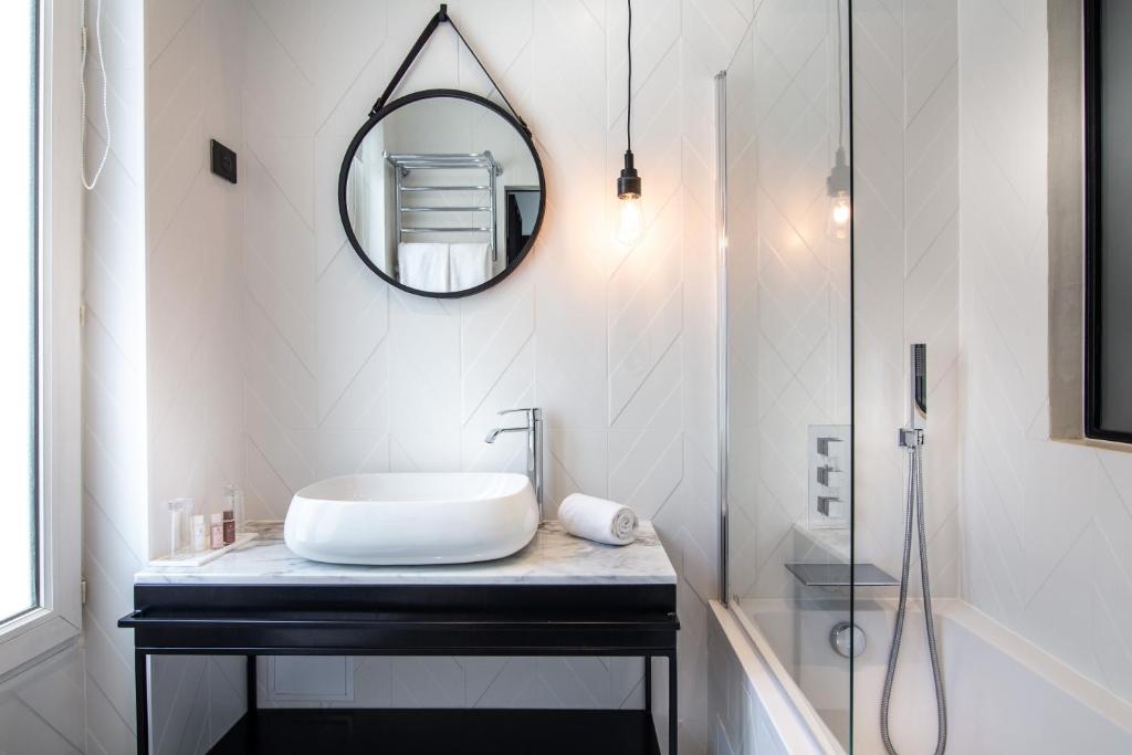 a bathroom with a sink and a mirror on a counter at Hôtel Royal Opéra in Paris