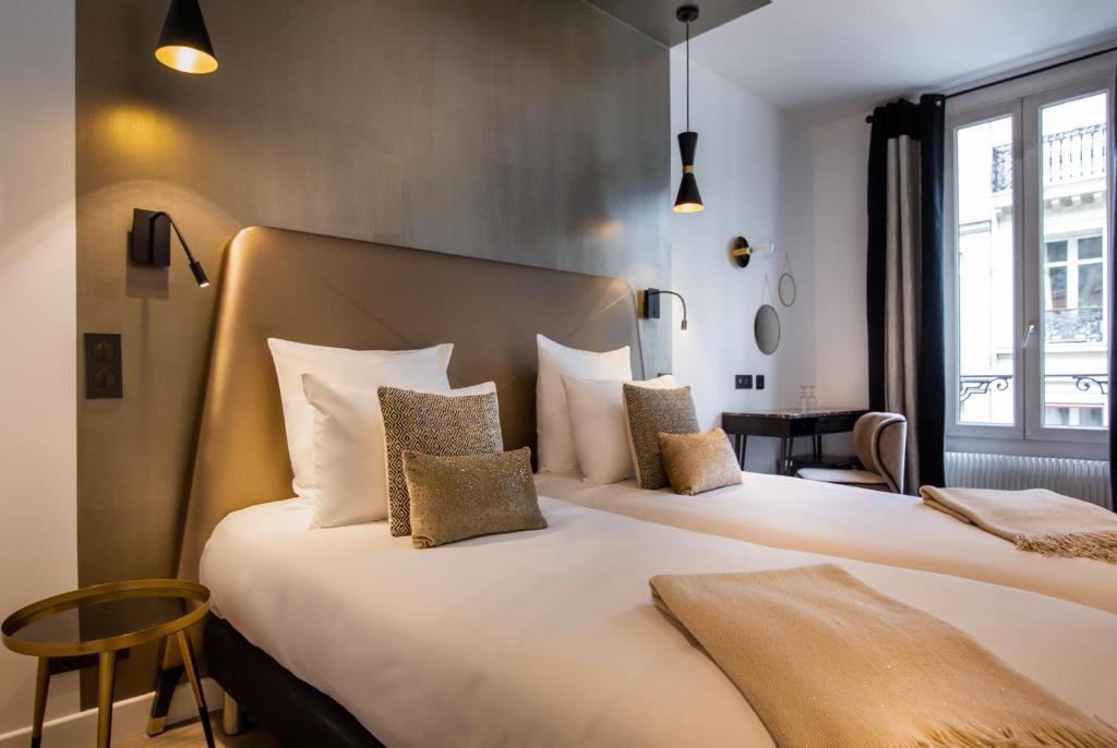 a hotel room with two beds and a window at Hôtel Royal Opéra in Paris