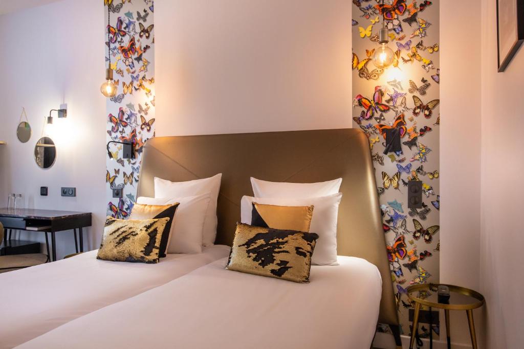 a bedroom with a bed with white sheets and pillows at Hôtel Royal Opéra in Paris