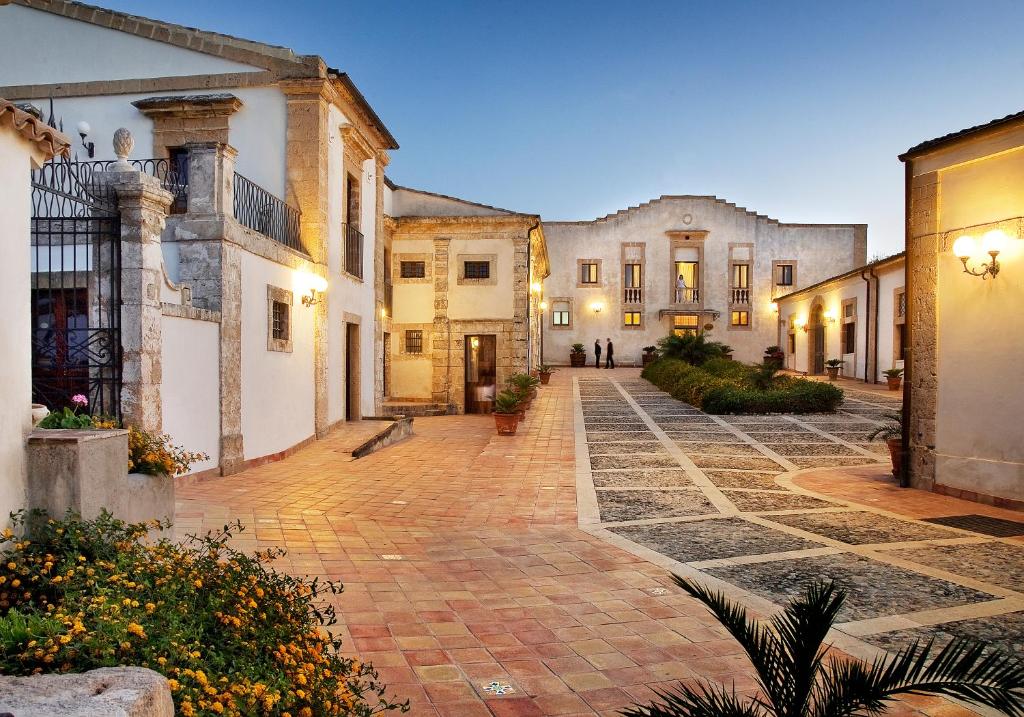 een binnenplaats van een huis met een geplaveide straat bij Hotel Villa Favorita in Noto