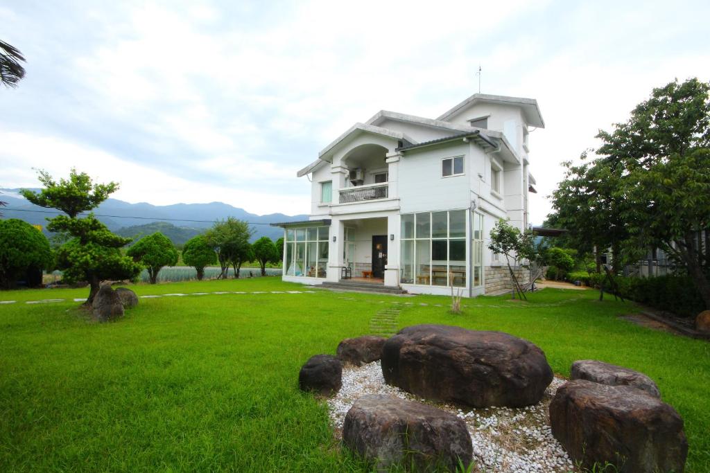 天福村的住宿－星宿度假別墅，院子里有大石头的白色房子