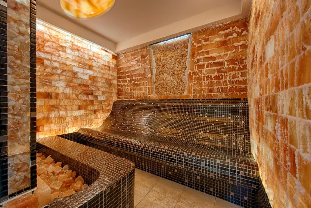 a sauna with a brick wall at Thermenwelt Hotel Pulverer in Bad Kleinkirchheim