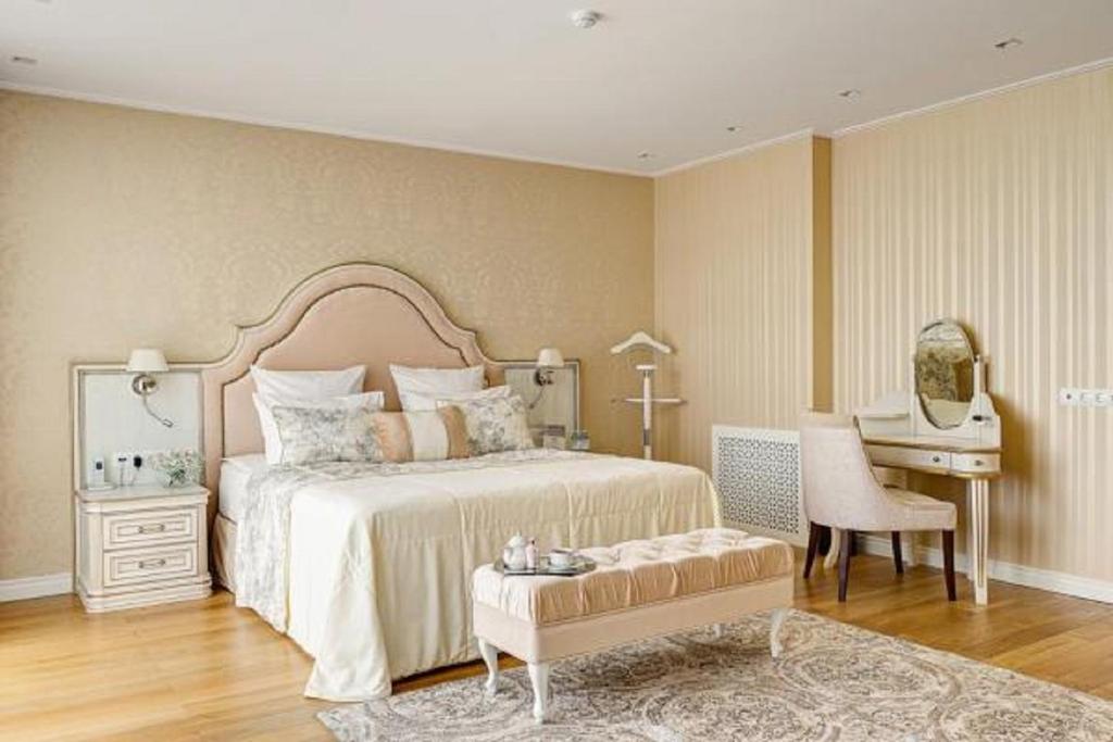 1 dormitorio con cama, escritorio y silla en Grand Hotel Zvezda, en Tver