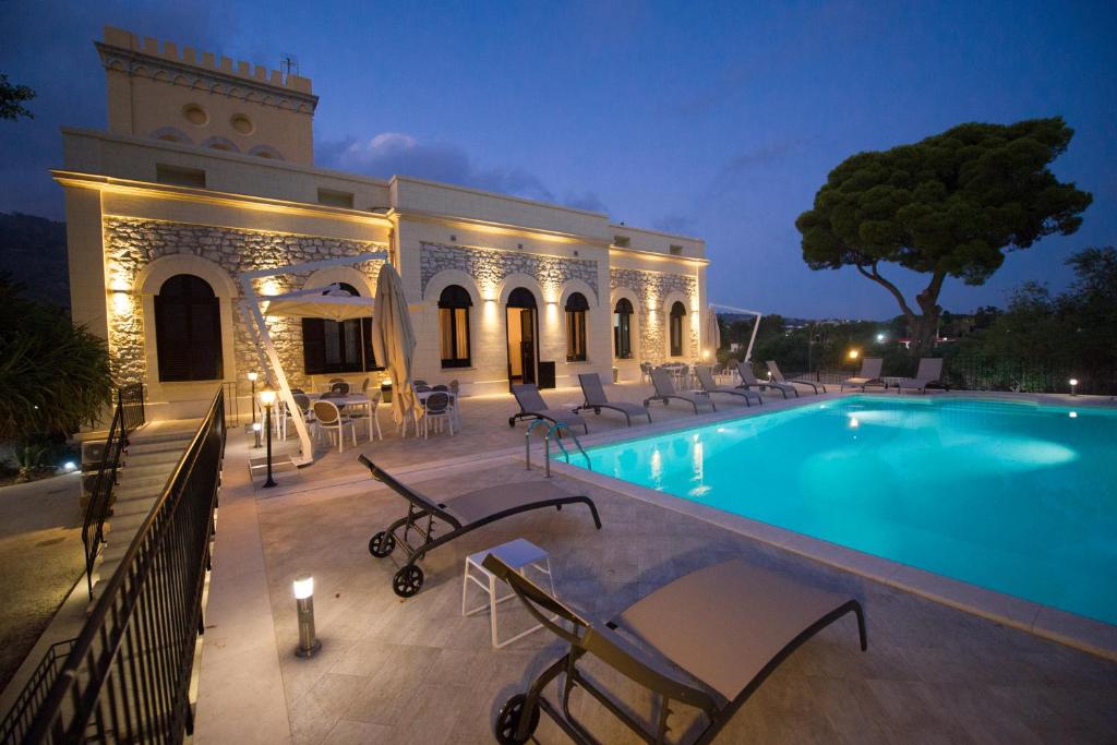 basen z krzesłami i budynek w obiekcie Villa le Torri B&B w Trapani