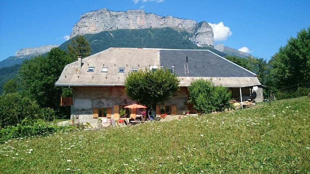 une maison dans un champ avec une montagne en arrière-plan dans l'établissement Ferme familiale chez Lili, à Alex