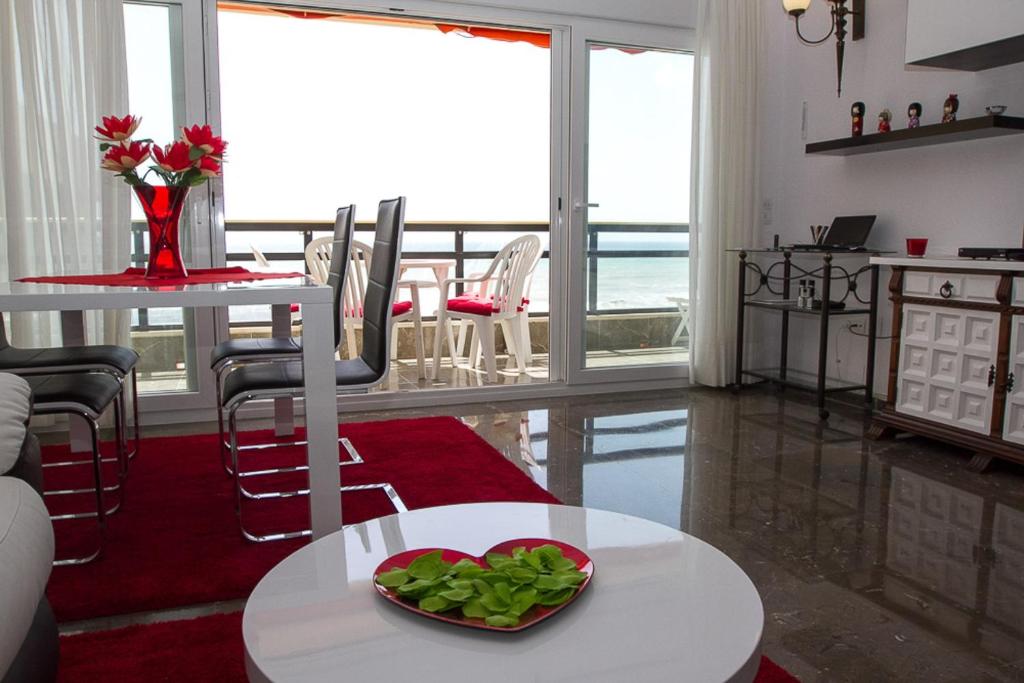 una sala de estar con una mesa con un tazón de verduras. en Carihuela, en Torremolinos