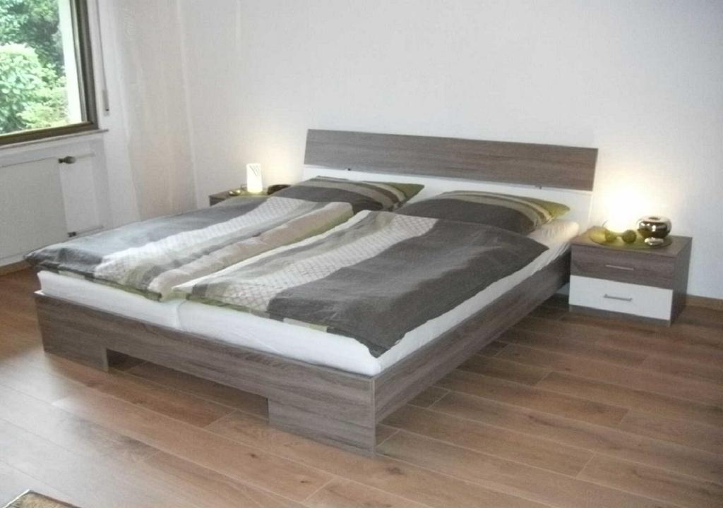 een groot bed in een slaapkamer met een houten vloer bij Apartment Heilbrünnchen in Emmelshausen