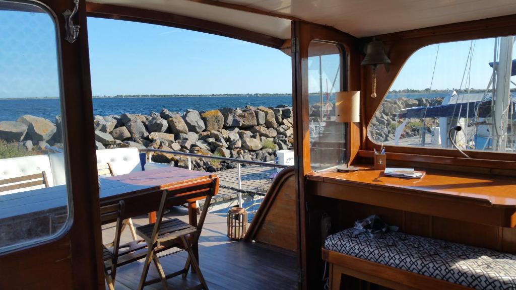 une table sur un bateau avec vue sur l'eau dans l'établissement Lady of Bahia, à Marseillan