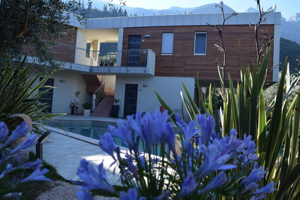 una casa con flores azules delante de ella en "CASABANA" - relax tutto l'anno - giardino - piscina Top, en Malcesine