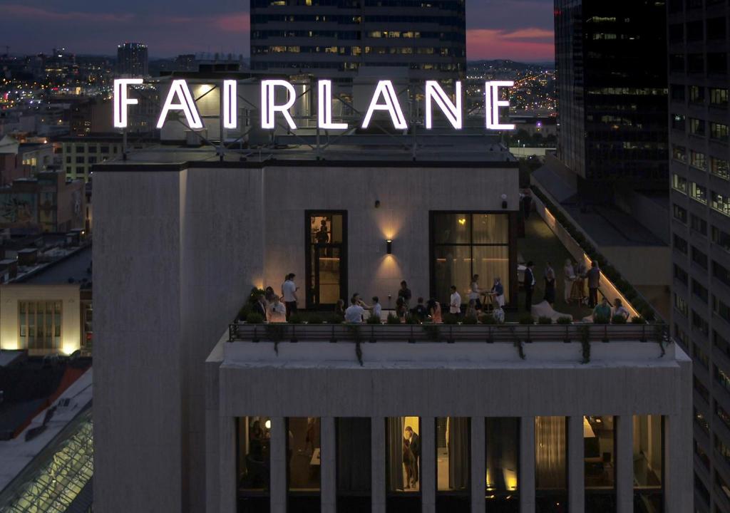 Fairlane Hotel Nashville, by Oliver في ناشفيل: مجموعة من الناس جالسين على سطح مبنى