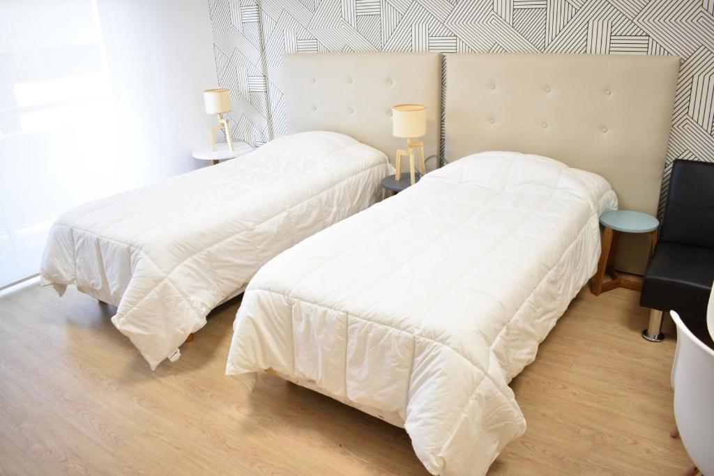 2 camas con sábanas blancas en una habitación en Loft para 4 personas 7º C en Buenos Aires