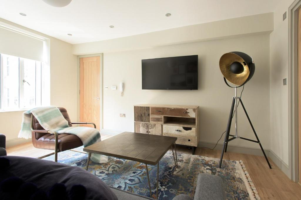 The New Bond Street Loft - Modern & Central 1BDR في لندن: غرفة معيشة مع تلفزيون بشاشة مسطحة على جدار