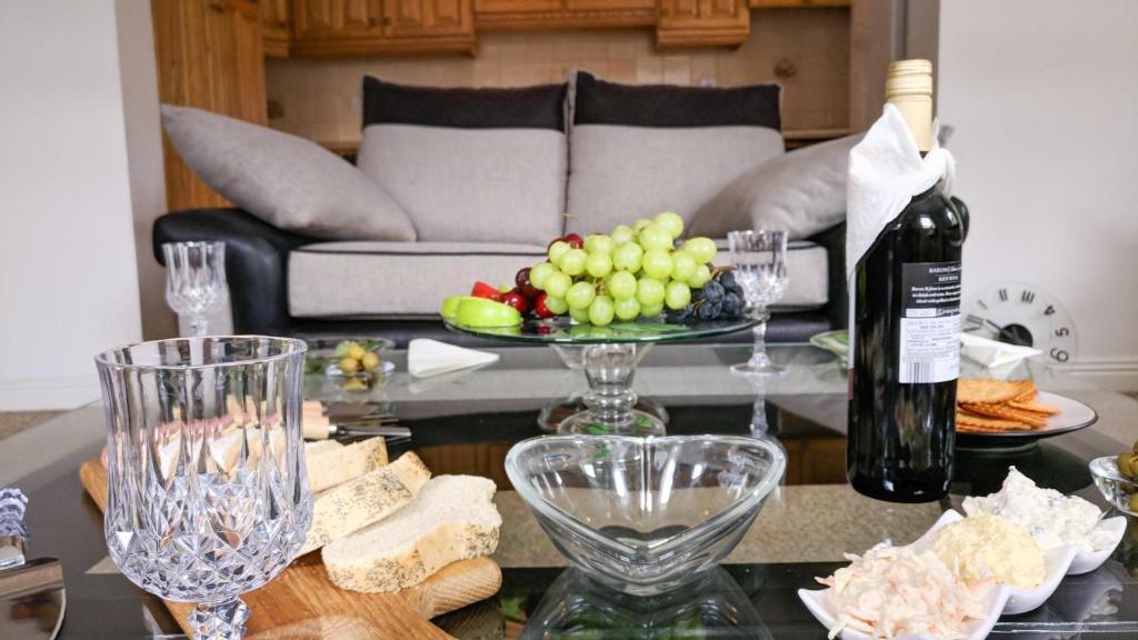 una sala de estar con una mesa con botellas de vino y copas de vino en Riverview Luxury Short Stay Apartment, en Enniscorthy