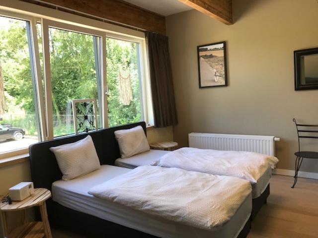 a bedroom with a bed and a couch and a window at Appartementen Leonardus in Valkenburg