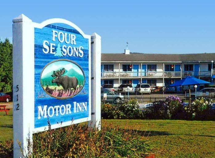 ein Schild für ein Hotel mit einem Schild für einen Gasthof in der Unterkunft Four Seasons Motor Inn in Twin Mountain
