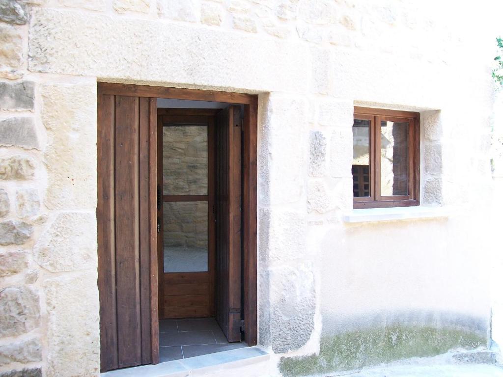 una puerta de madera en un edificio de piedra con 2 ventanas en Casa Manolita, en Calaceite