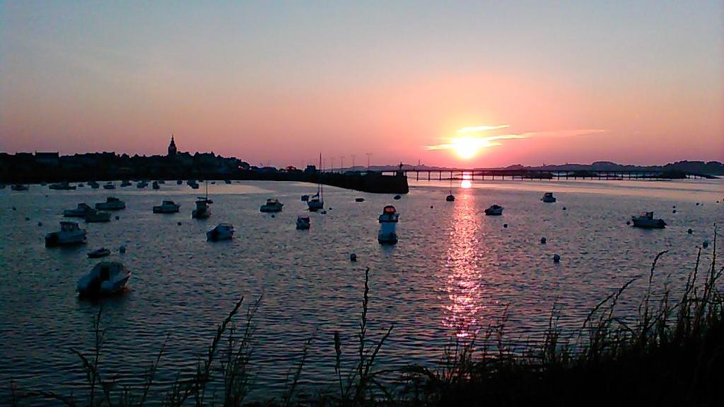a group of boats in the water at sunset at Logis Hotel Bellevue in Roscoff