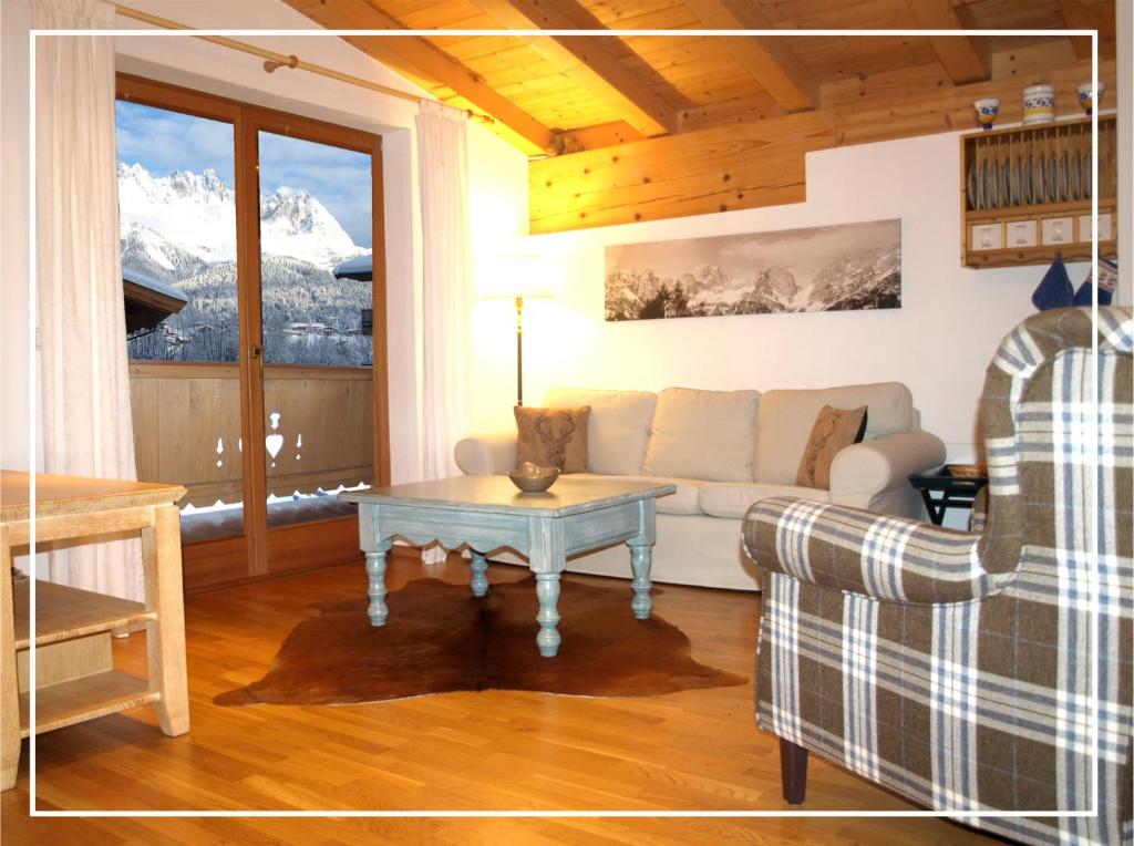 een woonkamer met een bank en een tafel bij Chalet Der Tyroler Adler im Zentrum in Going