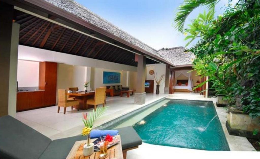 a villa with a swimming pool and a dining area at Nomad Hub Canggu Bali in Canggu