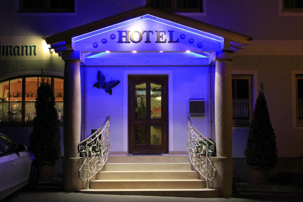 un hotel con una puerta delantera con luz azul en Hotel Pension Fleischmann, en Roding