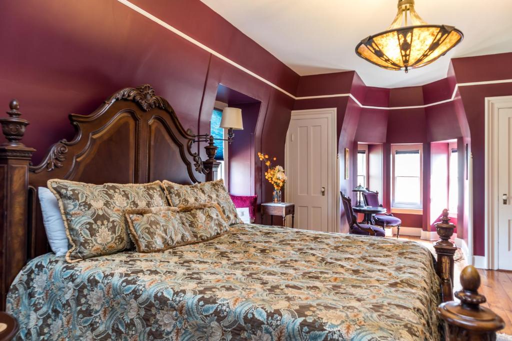 a bedroom with a large bed with purple walls at The Bevin House B&B in East Hampton